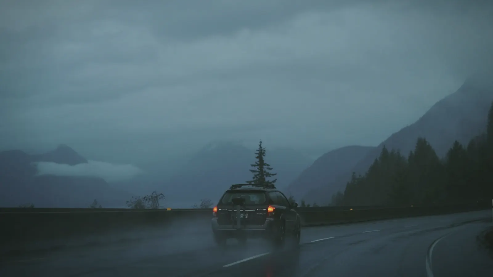 BC coastal mountain road with a car, appraisal checklist, and calculator for vehicle valuation